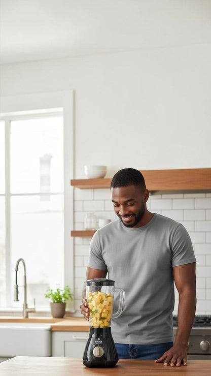 Hombre sonriente usando la licuadora negra Castor UP IMUSA PowerMix de 1.5 litros en una cocina moderna.