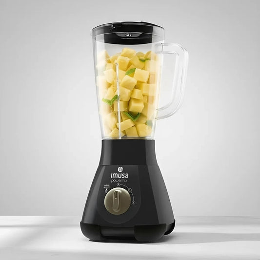 Licuadora Castor UP Imusa Powermix negra con jarra transparente llena de trozos de piña sobre encimera blanca